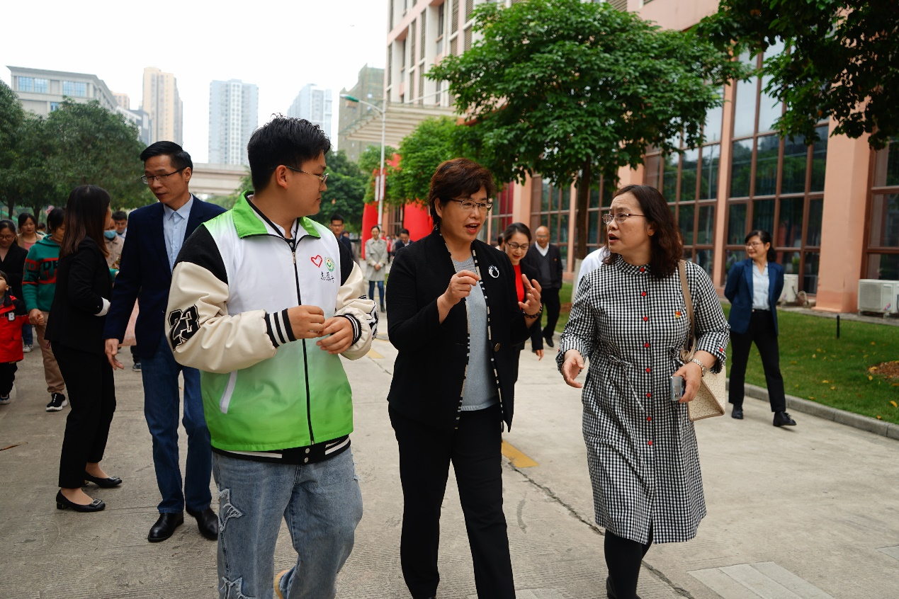 自治区残联党组书记、理事长黄丽娟（中）与开云线上平台（集团）官方网站设备学院党总支书记侯文淑（右）对活动进行深入沟通交流