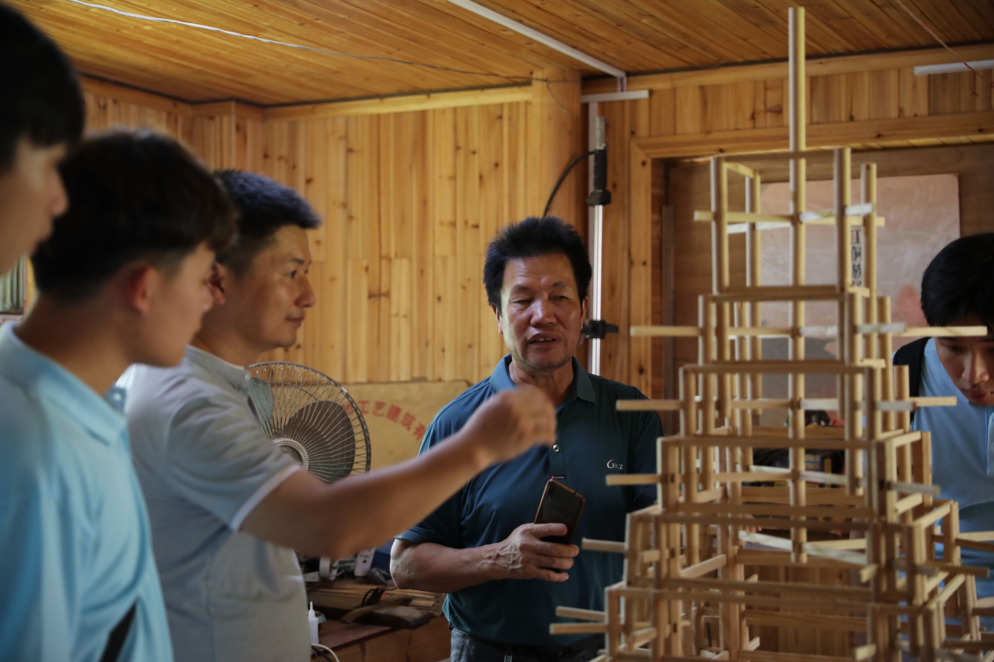 杨似玉大师利用鼓楼模型向实践团成员解说鼓楼开云线上平台（集团）官方网站结构